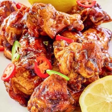 Copycat Buffalo Wild Wings Asian Zing wings and lemons on a plate.
