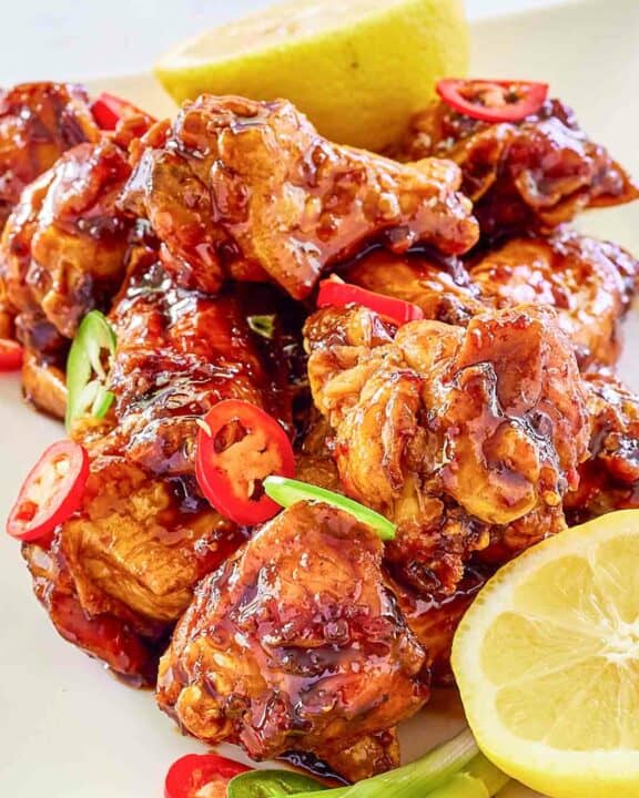 Copycat Buffalo Wild Wings Asian Zing wings and lemons on a plate.