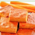 Carrot pudding slices and three carrots behind them.