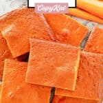 Overhead view of carrot pudding slices and carrots beside them.