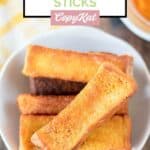 Overhead view of homemade Burger King French toast sticks on a white plate.