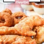 Homemade Long John Silver's chicken planks and onion rings on a plate.