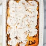 Overhead view of homemade overnight cinnamon rolls in a white baking dish.