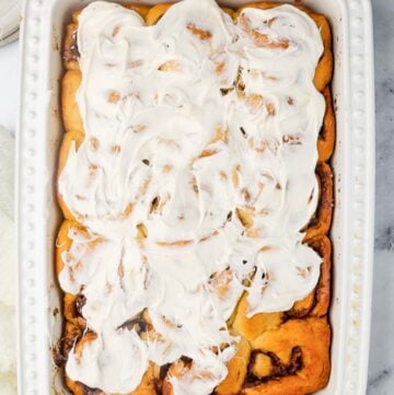 Overhead view of homemade overnight cinnamon rolls in a white baking dish.