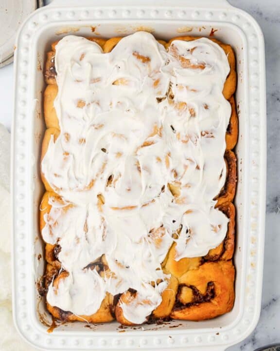 Overhead view of homemade overnight cinnamon rolls in a white baking dish.