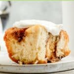 Frosted overnight cinnamon roll on a plate.