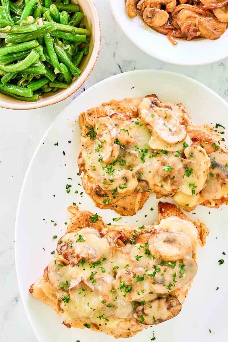 Overhead view of copycat Texas Roadhouse smothered chicken on a plate.