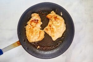 Cooked chicken breasts in a skillet.