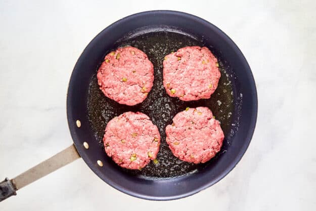 21 Club burger patties in a skillet.
