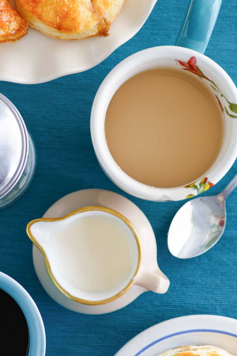 Overhead view of homemade amaretto coffee creamer and a cup of coffee.