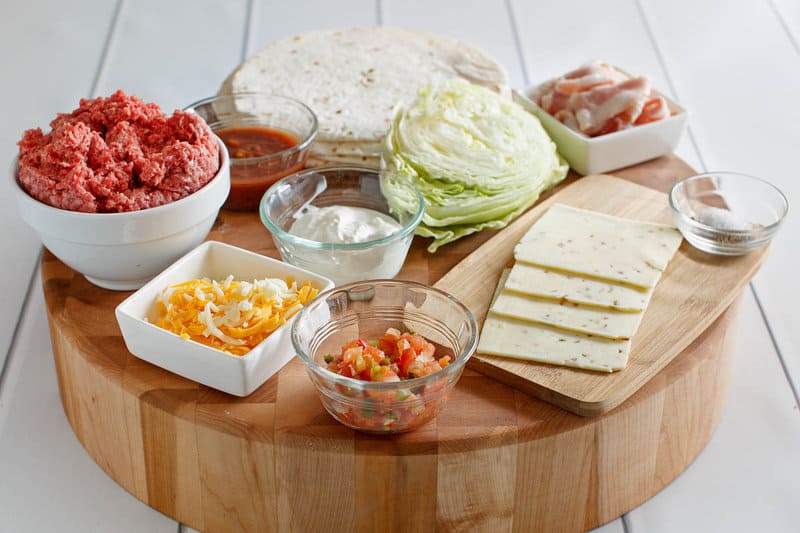 Copycat Applebee's quesadilla burger ingredients on a wood board.