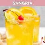 Homemade Applebee's white peach sangria garnished with lemon, lime, and a cherry.