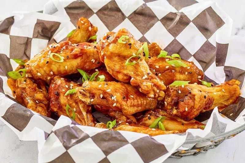 Copycat Buffalo Wild Wings Buffalo wings on parchment paper in a serving basket.