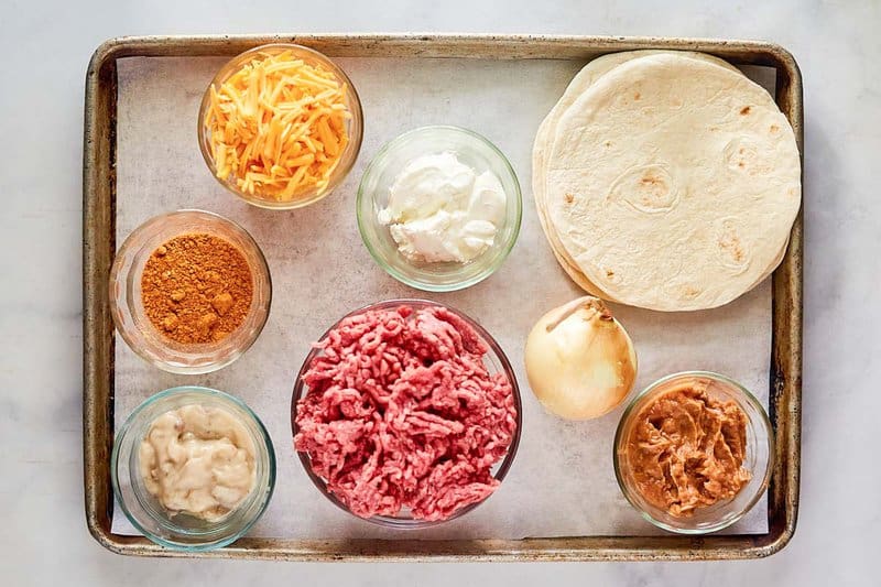 Burrito casserole ingredients on a tray.
