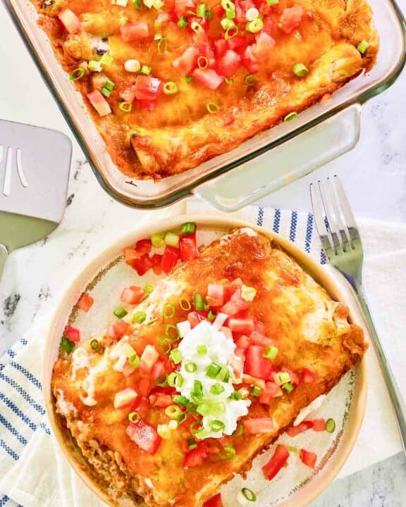 Overhead view of burrito casserole in a baking dish and on a plate.