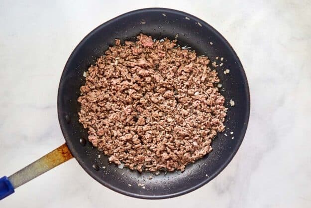 Cooked ground beef in a skillet.