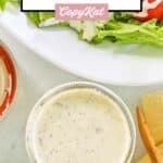 Overhead view of dill pickle ranch dressing in a small glass jar.