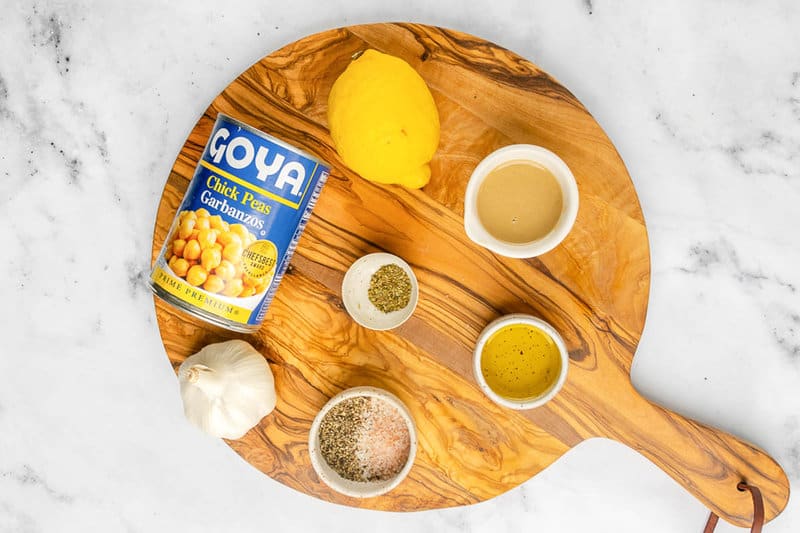 Garlic hummus ingredients on a wood board.