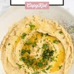 Closeup overhead view of homemade garlic hummus in a bowl.