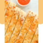 Overhead view of homemade Pizza Hut cheese sticks and marinara dipping sauce.