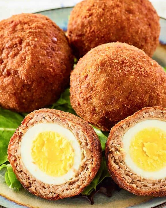 Scotch eggs on a plate.