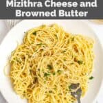 Overhead view of homemade spaghetti with mizithra cheese and browned butter sauce on a white plate.