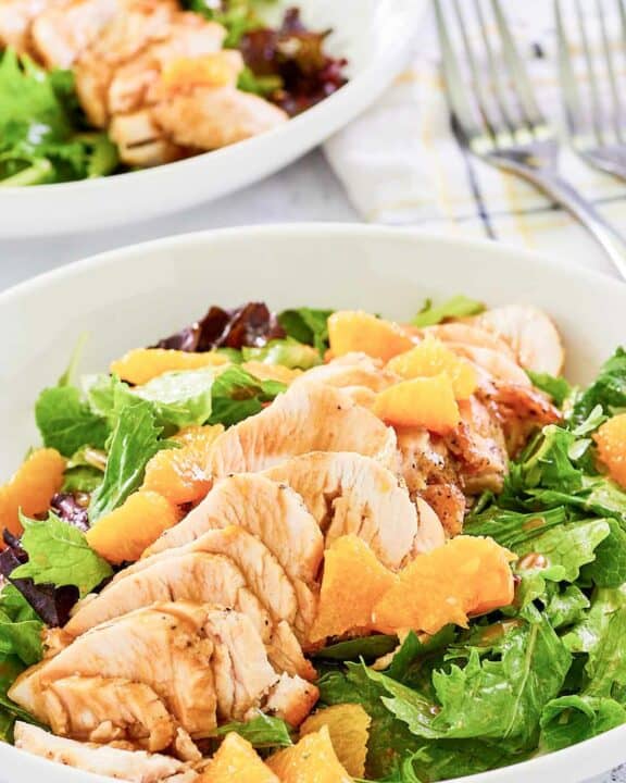 Copycat TGI Friday's mandarin orange salad with chicken in a white bowl.