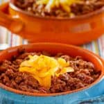 Closeup of homemade Wick Fowler 2 alarm chili in a blue bowl.