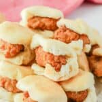 Homemade Chick Fil A chicken minis stacked on a plate.
