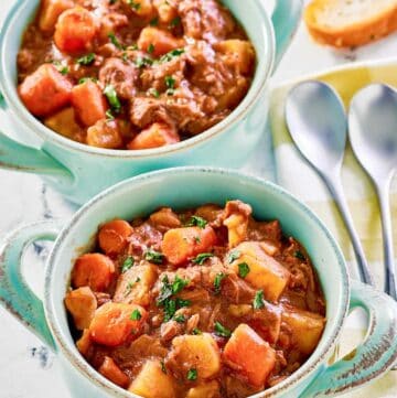 Crockpot beef stew with potatoes and carrots in two bowls.