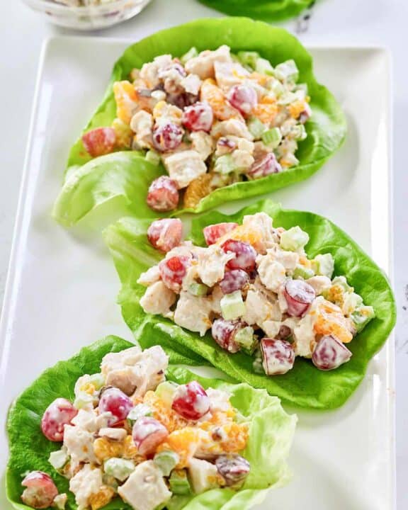 Fruity chicken salad with grapes, mandarin oranges, and nuts on a platter.