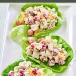 Three servings of fruity chicken salad on top of butter lettuce leaves on a platter.