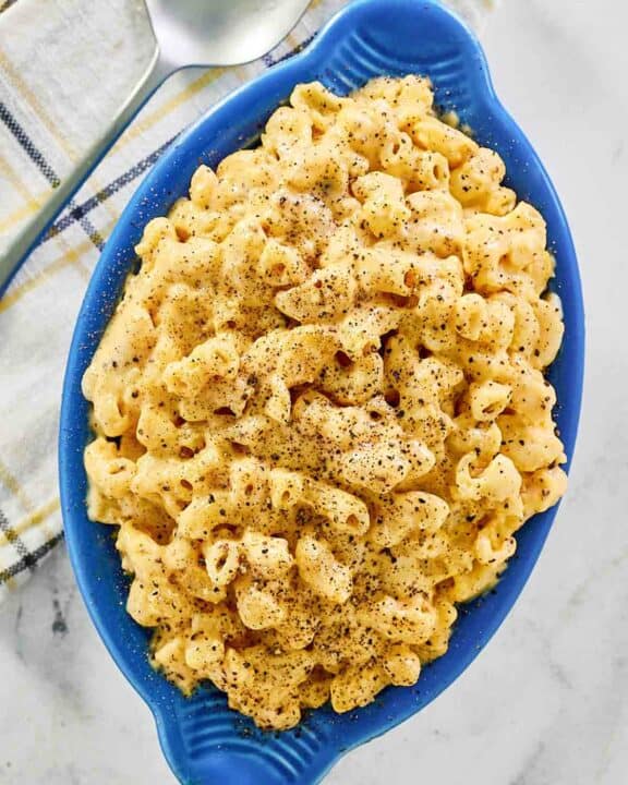 Homemade mac and cheese, a spoon, and a cloth napkin.