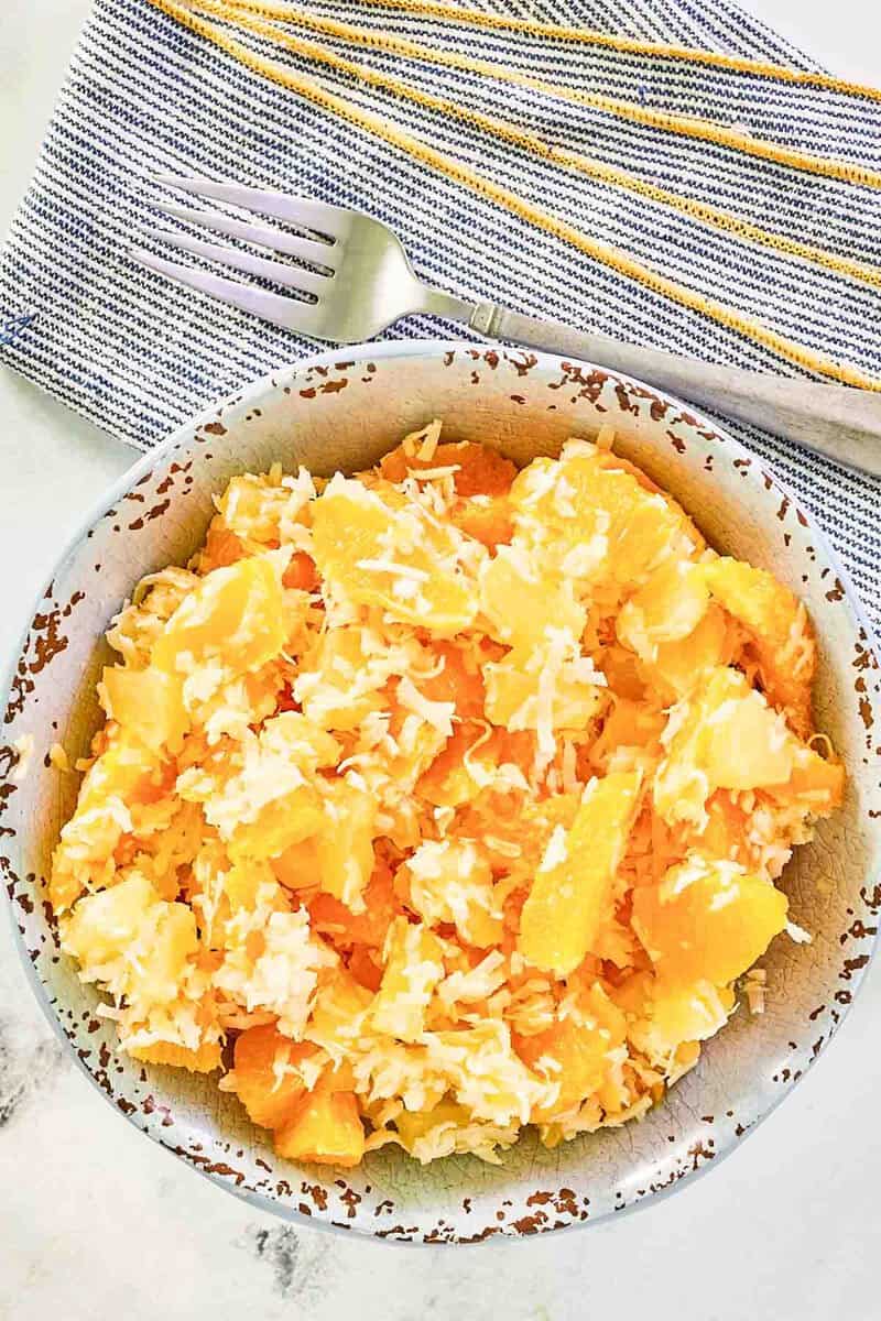 Copycat Luby's ambrosia fruit salad and a fork on a cloth napkin.