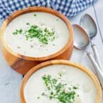 Homemade Red Lobster clam chowder in two bowls and two spoons next to them.