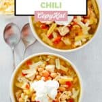 Two bowls of homemade Ruby Tuesday white chicken chili and a bowl of shredded cheese.