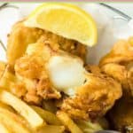 Beer battered fish and chips and one broken in half to show the inside.