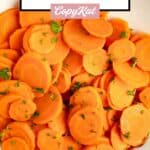 Sliced cooked carrots on a plate.