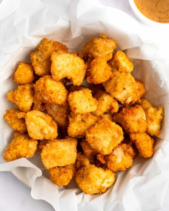 Copycat Chick Fil A chicken nuggets in a parchment paper lined basket.
