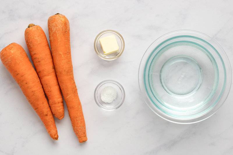 Cooked carrots ingredients on a marble surface.