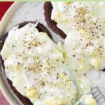Two pieces of toast with creamed eggs on them.