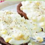 Creamed eggs on toast and a fork on a plate.