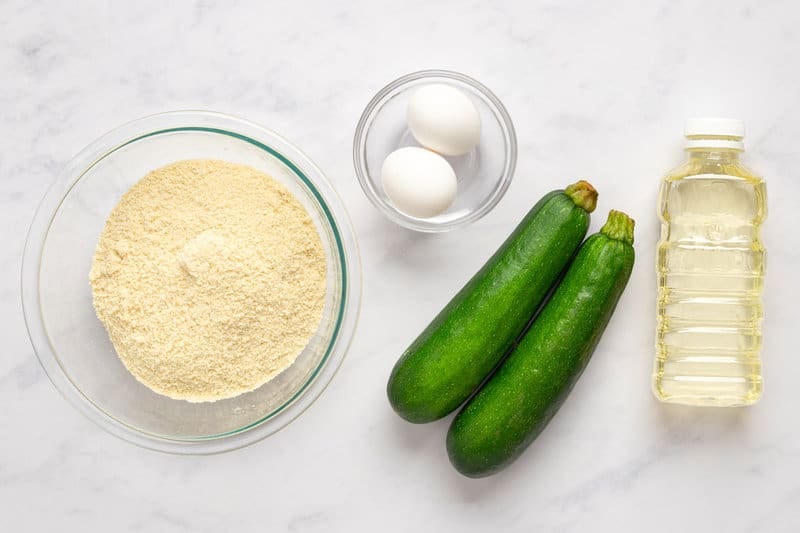 Fried zucchini ingredients on a marble surface.