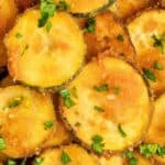 Fried zucchini rounds garnished with parsley.