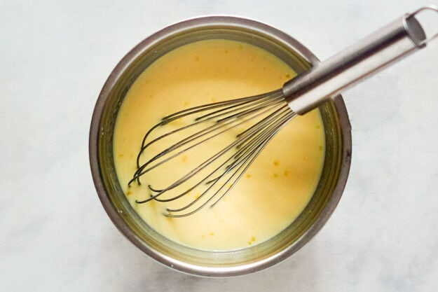 Banana pudding and a whisk in a mixing bowl.