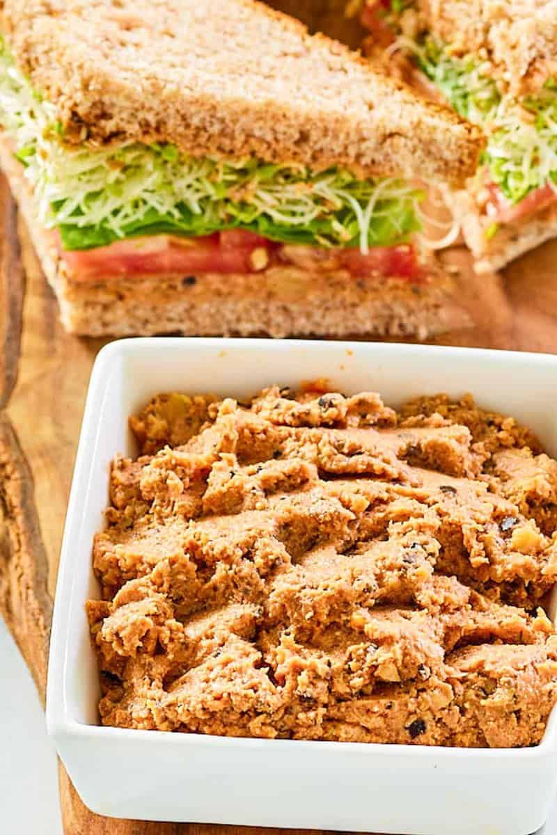 Homemade Loma Linda sandwich spread in a small bowl and a sandwich next to it.
