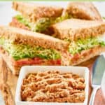 Homemade Loma Linda sandwich spread in a small square bowl and sandwiches behind it.