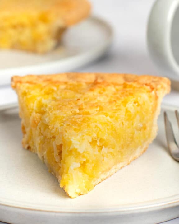 Copycat Luby's Hawaiian pie slice on a plate and the pie behind it.