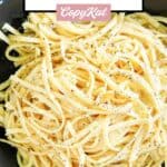 A bowl of pasta tossed with egg, garlic, and parmesan cheese.
