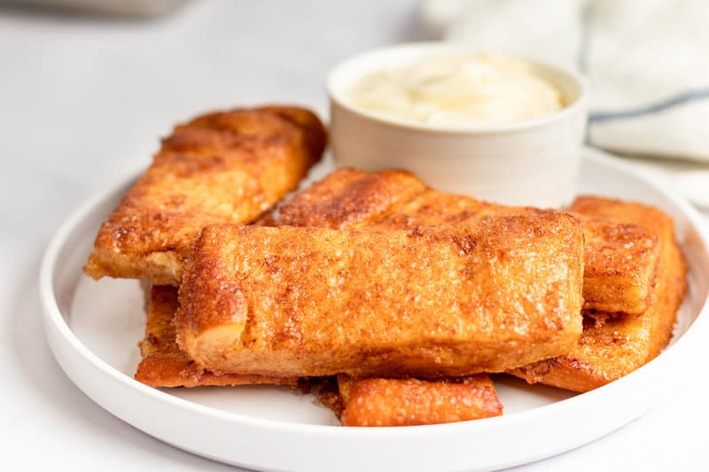 Homemade Pizza Hut cinnamon sticks and dipping sauce on a plate.